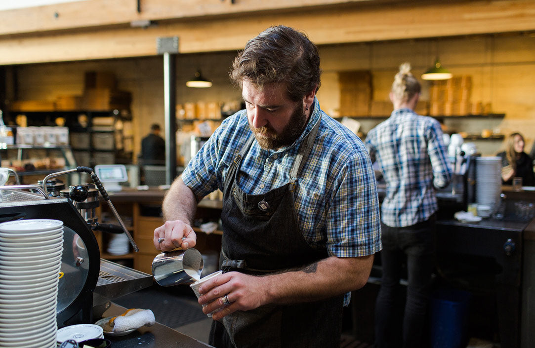 Barista pouring steamed milk in to make a Latte at Sightglass Coffee's SoMa location (San Francisco).