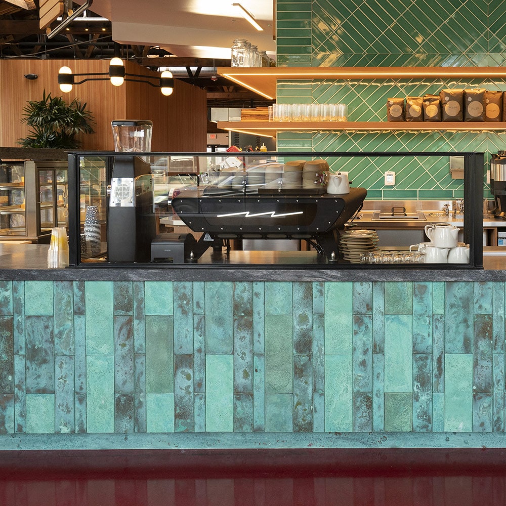 Sightglass Coffee counter at Sycamore, Hollywood, Los Angeles, with malachite green tiles and a mid-century vibe.